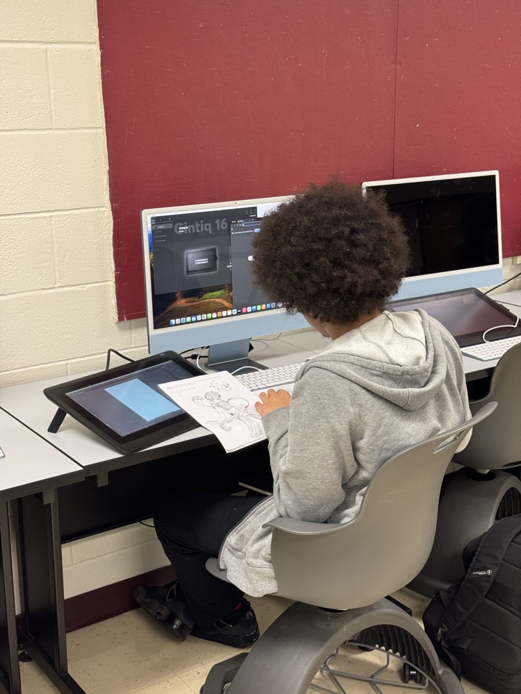 Picture of student sitting as desk working on his computer