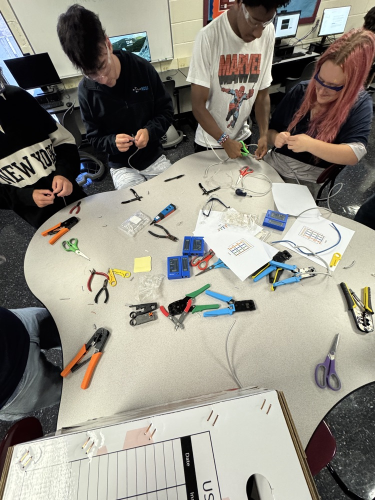 multiple students around a table working on computer wire
