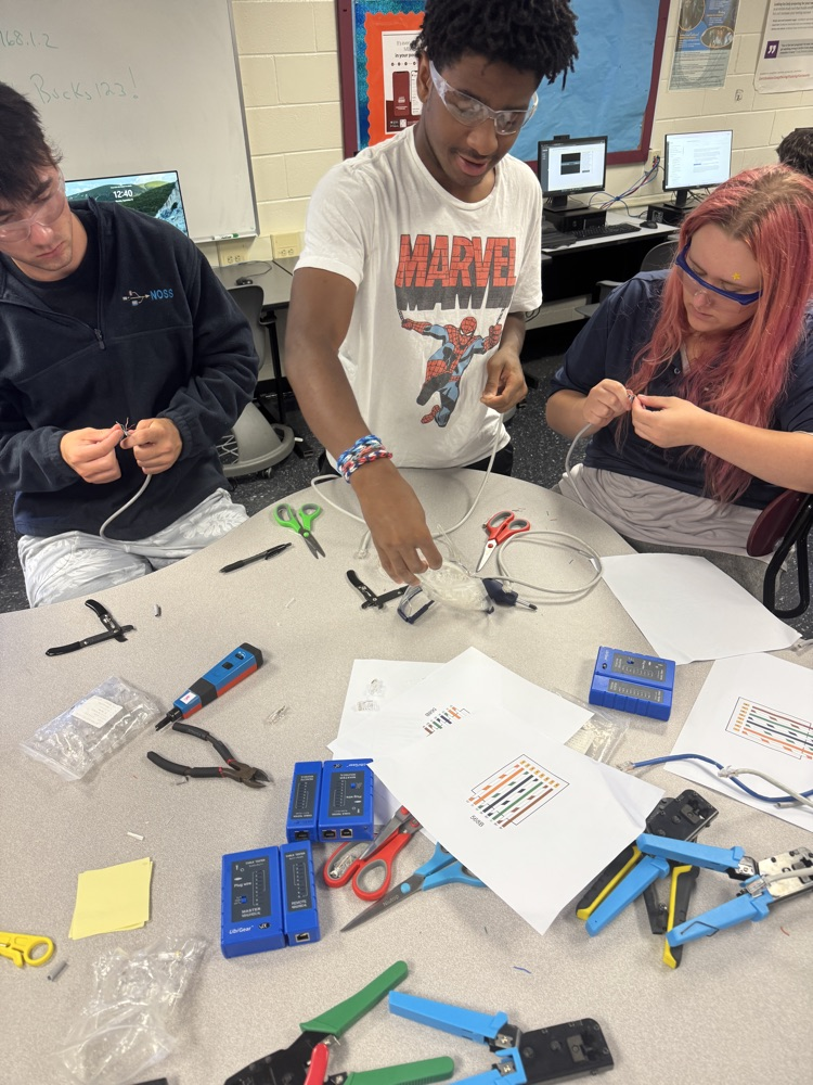 multiple students working around a table on computer wire