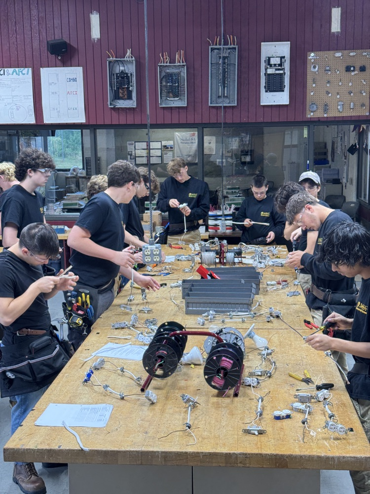 multiple electrical students with safety glasses on and t
