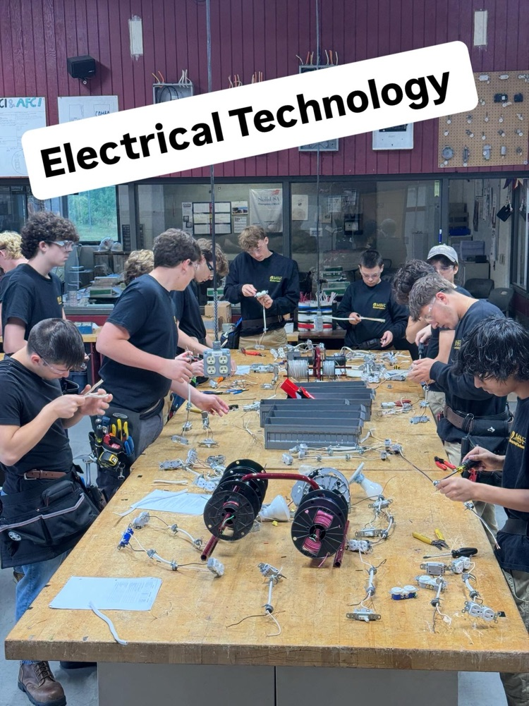 multiple electrical students with safety glasses on and t