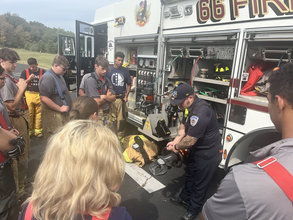 Multiple students around the fire Truck Sixty Six Firehouse showing them equipment