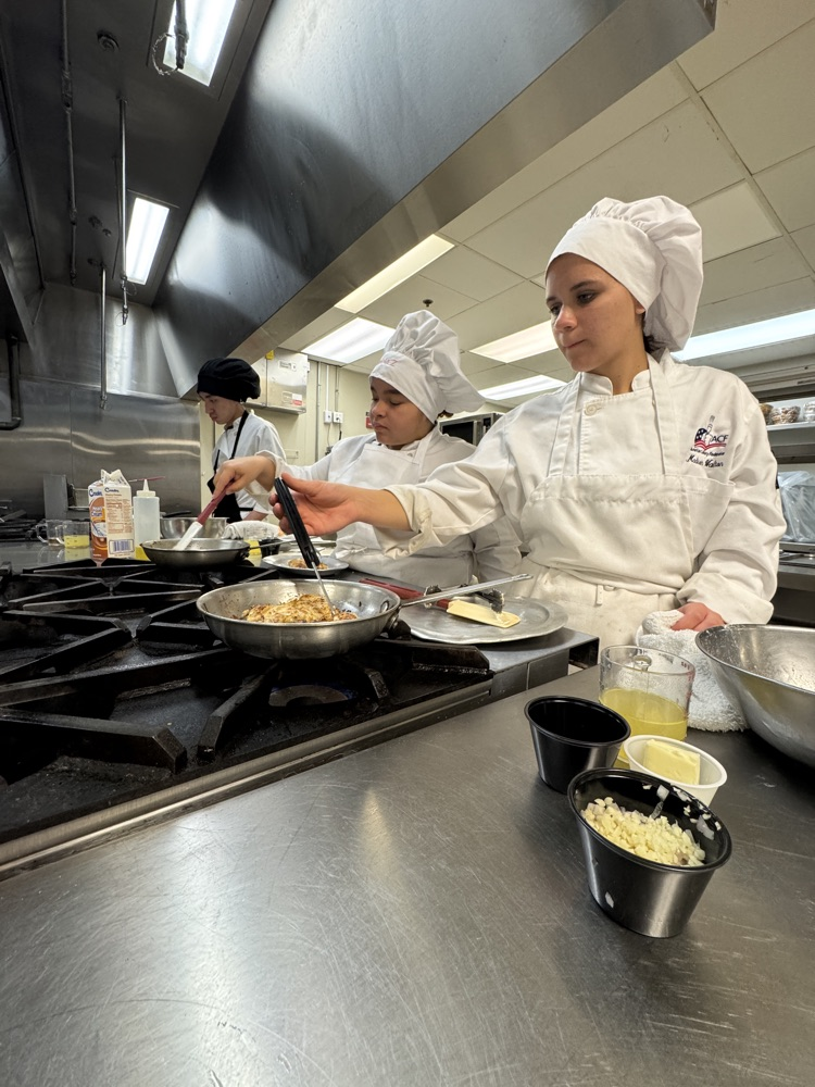 Conary art students and their uniform is cooking on the stove