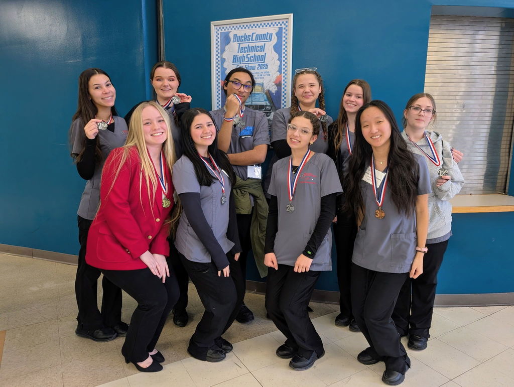 Photo of the medical and health profession students one student in her red skills USA jacket. All smiles on their faces, all of them with metals around their neck