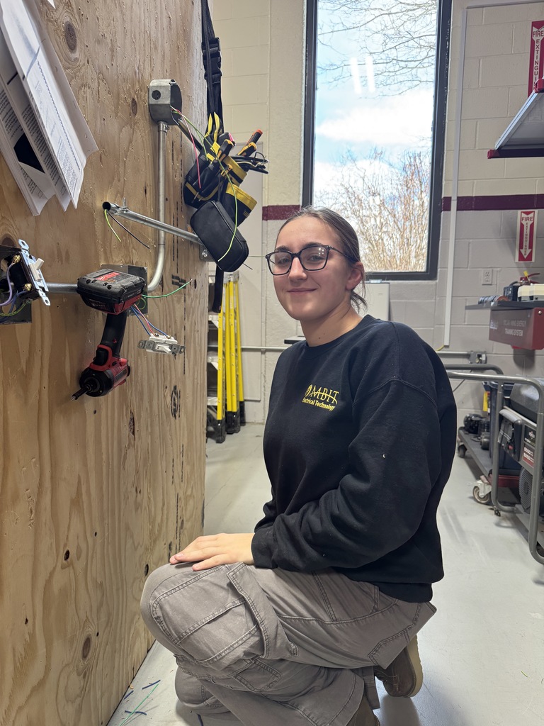 So electrical students smile on her face, black sweatshirts as M, B I T electrical technology and the panels