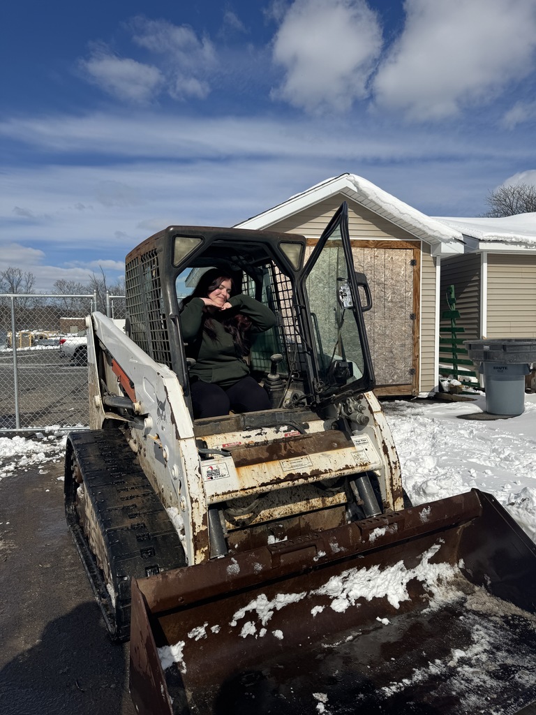 This is a landscape system and outdoor construction student. She's an IA. Looks like a bobcat and she's smiling