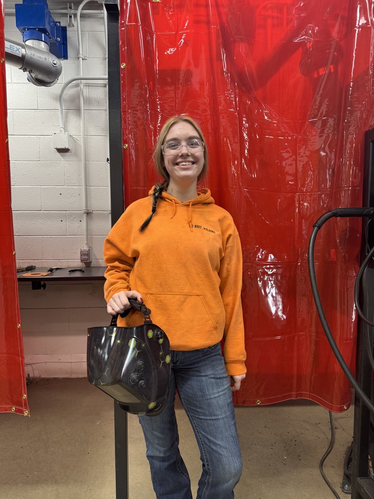 Just say welding student. She's outside the booth, she's got a braid, she said. Safety glasses on, smile on her face, armed sweatshirt, jeans and a welding