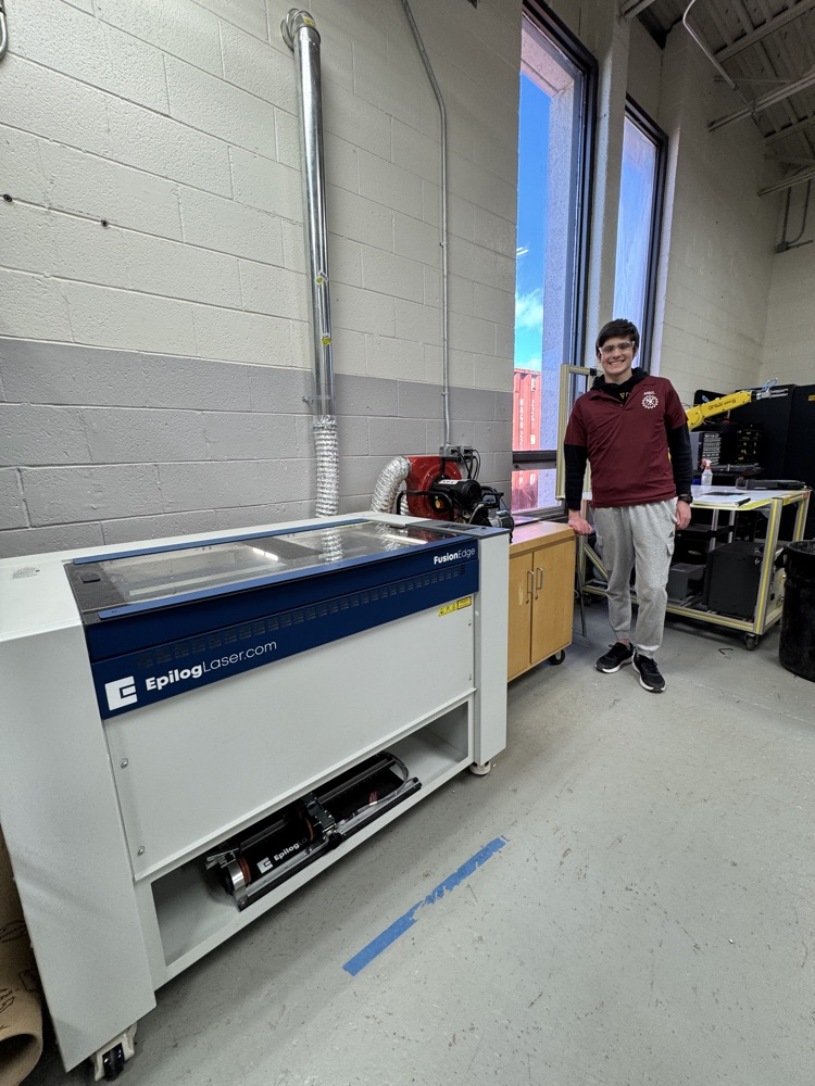 an engineering student next to the laser cutter