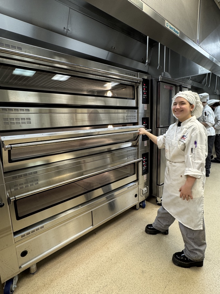 it’s a culinary student in front of the very impressive big oven