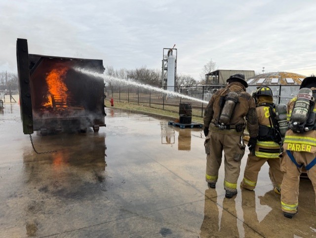 This is three of the public safety students in their gear with their tanks on fire, training gear with their tanks on, putting out a real live fire in a in