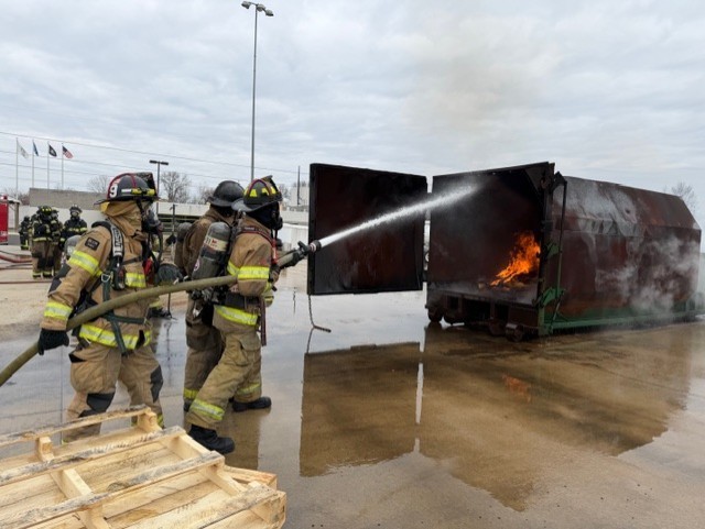 This is three in public safety students again with holding the hose and they're putting out a fire