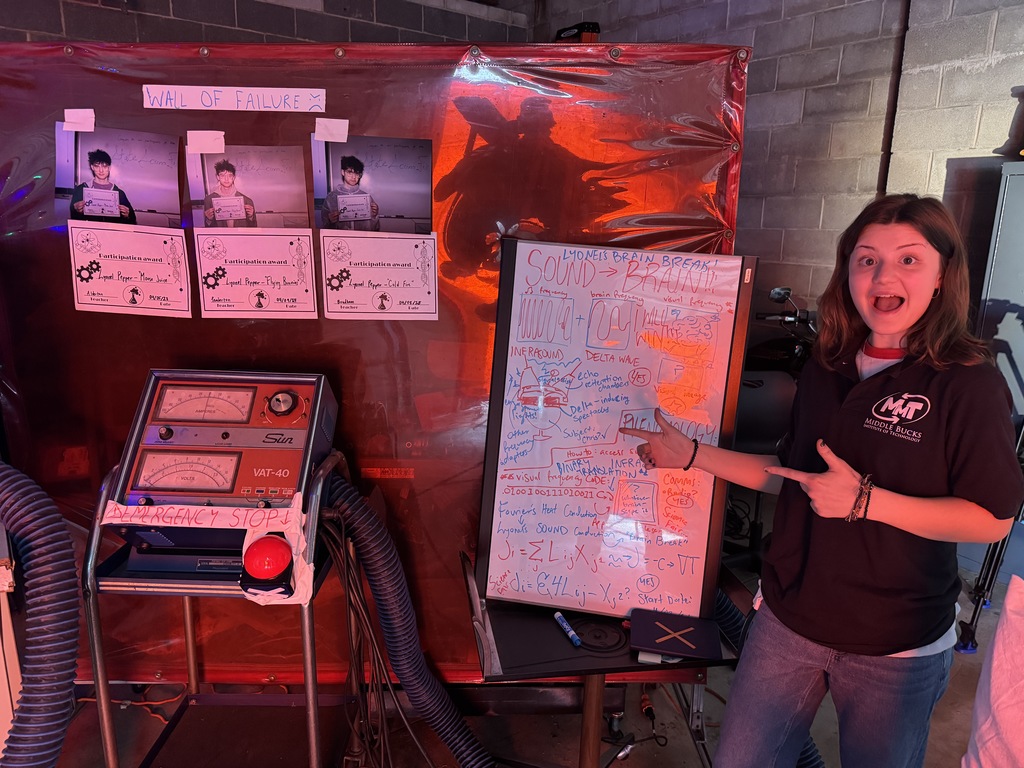 A big smile on her face pointing to the storyboard for their sci-fi film