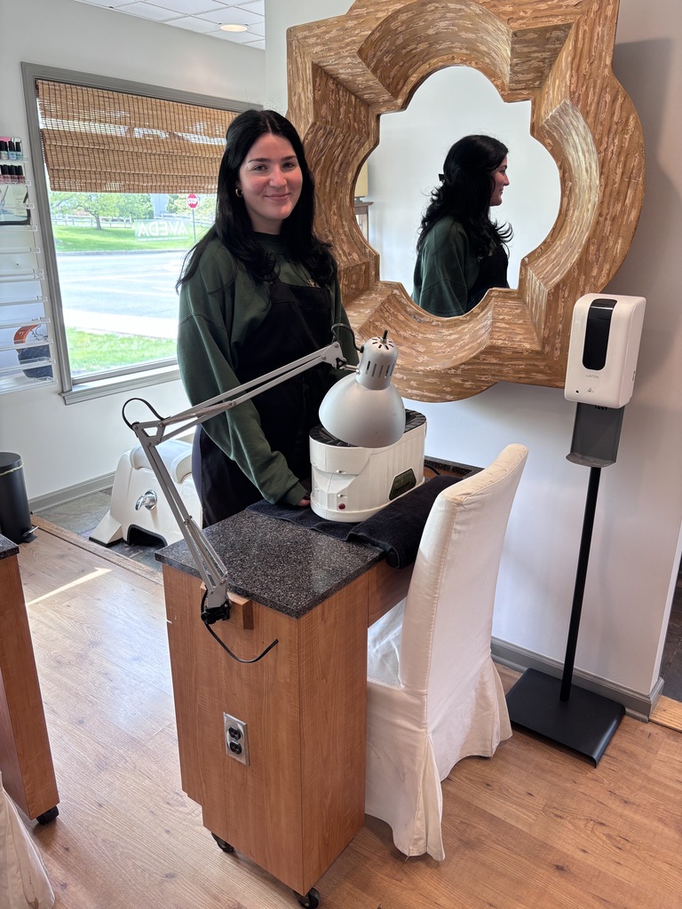 One of the students looks like she's had a salon at a nail table. There's a mirror by her. She just got a smile on her face