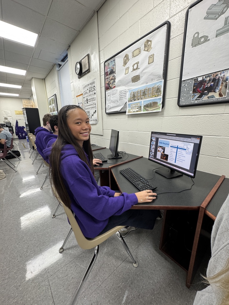 What's a photo of a architecture Student she's in her purple sweatshirt working on her computer