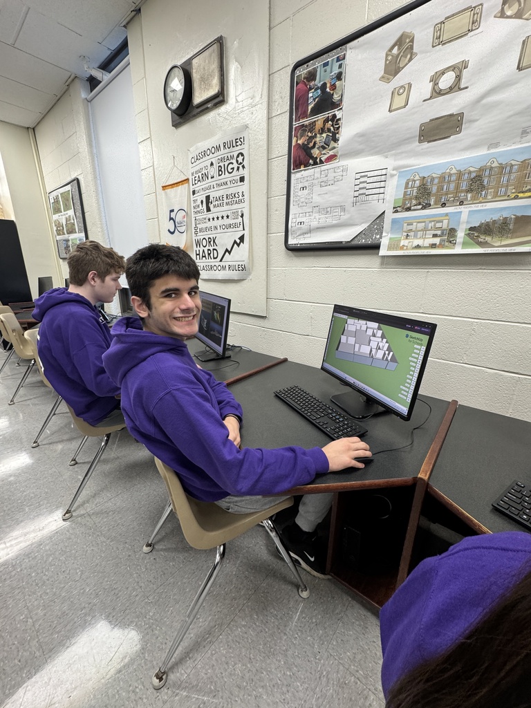 Picture of a architecture student working on a project on his computer purple sweatshirt