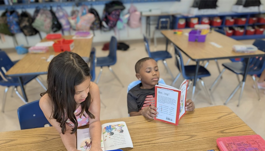 Two students reading at a desk.