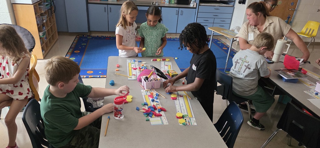 A group of students using shapes to build new shapes.