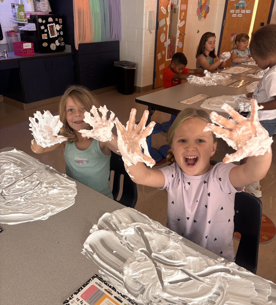Two students with shaving cream on hands.