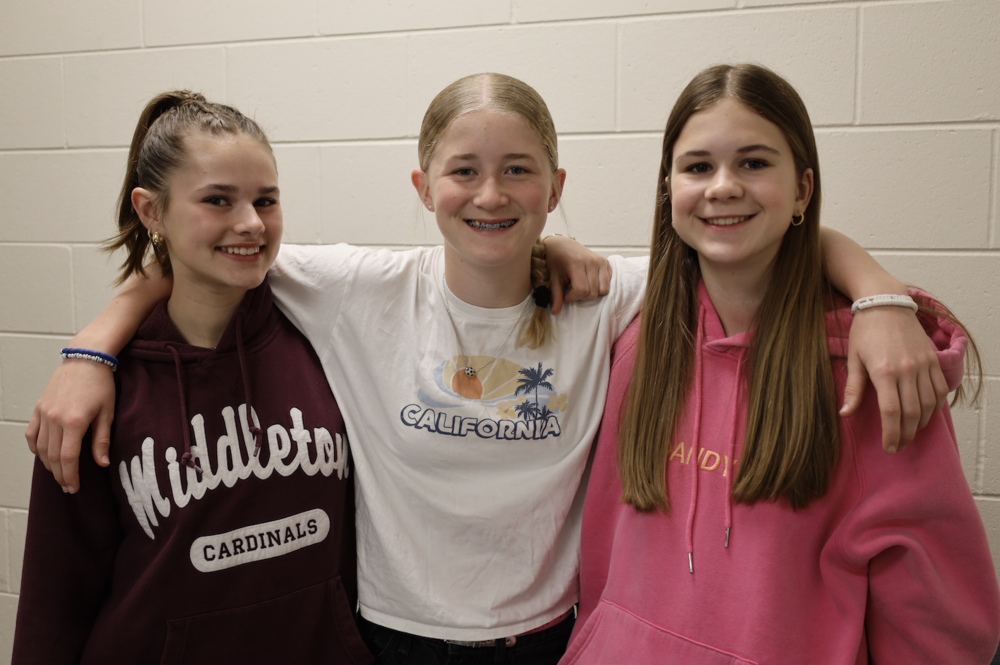 Three students smile and pose for group photo