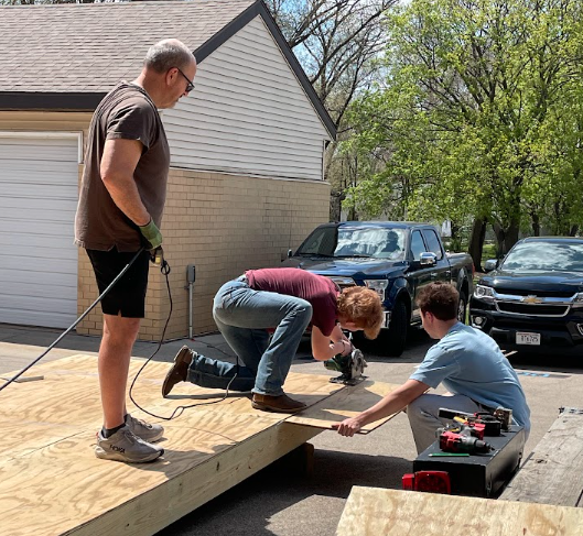 Mr. Zander and two students build a solar kiln
