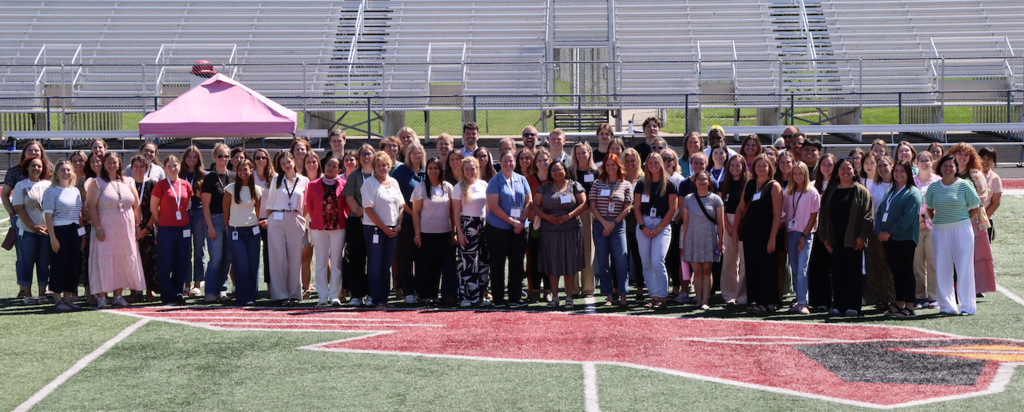 new educators' group photo on football field