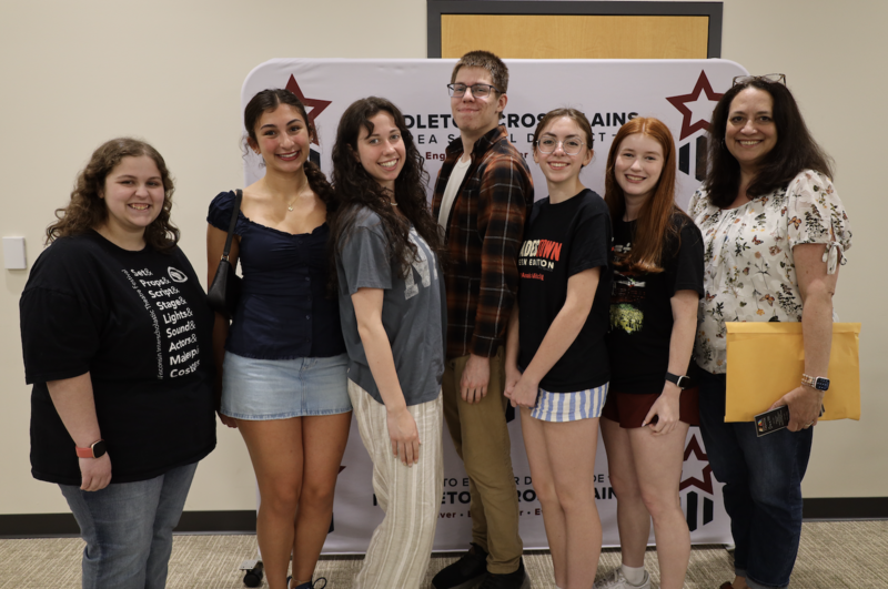 Theater director Katrina Brunner and students from the production of Hadestown: Teen Edition smile and pose for group photo