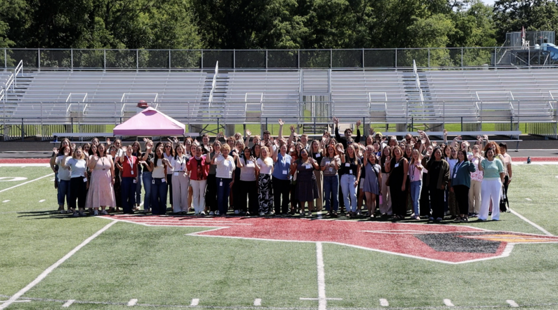 New MCPASD educators stand on the football field and cheer