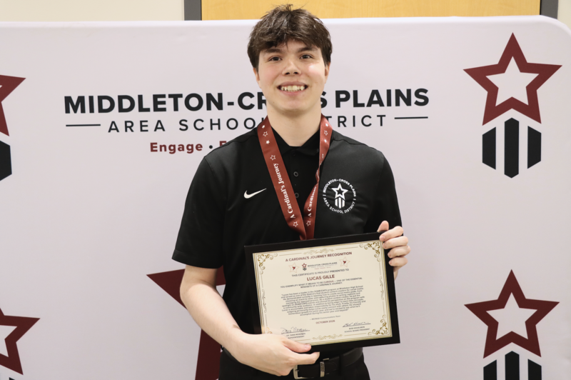 Lucas Gille smiling and hold his Cardinal's Journey Award