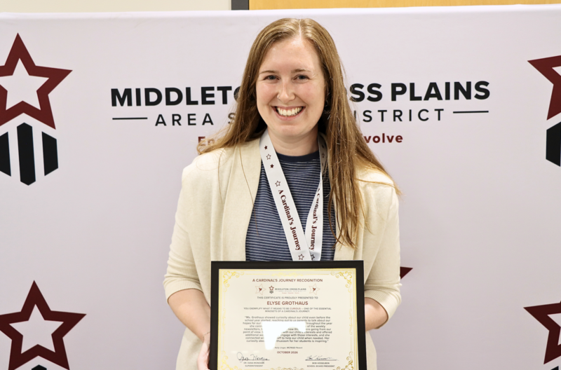 Elyse Grothaus smiling and holding her Cardinal's Journey Award