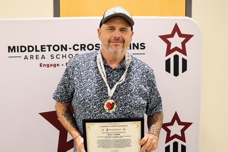 Scott Jones smiling and holding his Cardinal's Journey Award