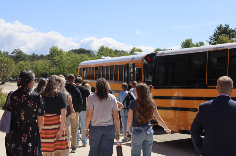 Staff members walking towards school buses outside