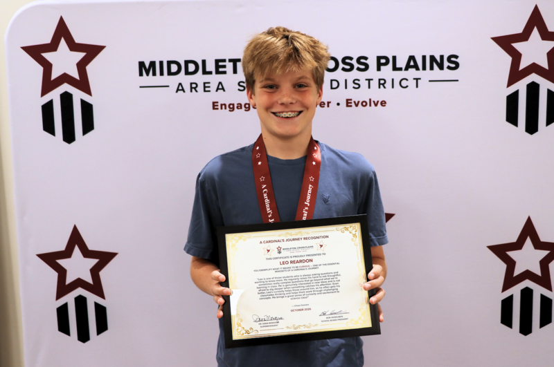 Leo Reardon smiling and holding his Cardinal's Journey Award