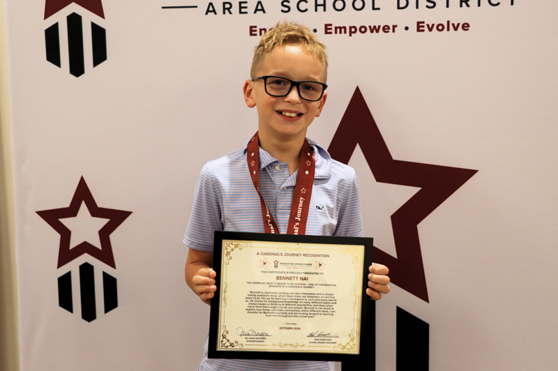 Bennett Nai smiling and holding his Cardinal's Journey Award