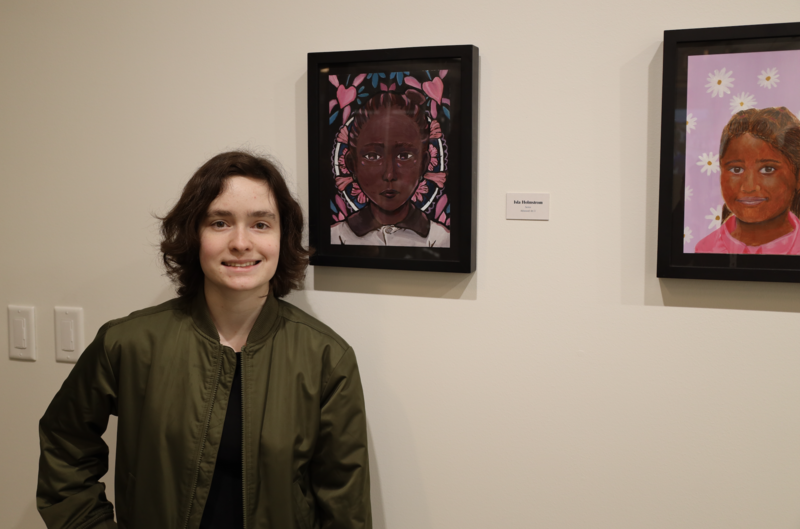 Middleton High School student poses with artwork in the Project Joy Art Gallery