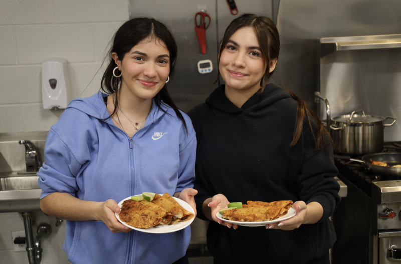 Culinary students in Middleton High School's CTE program smiling while holding tacos