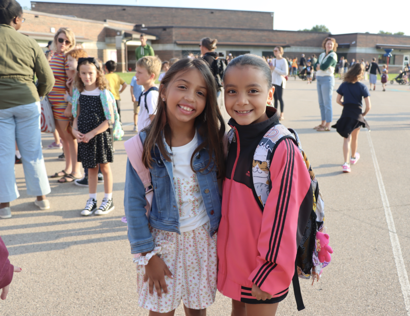 Students smiling outside while waiting to go in for school