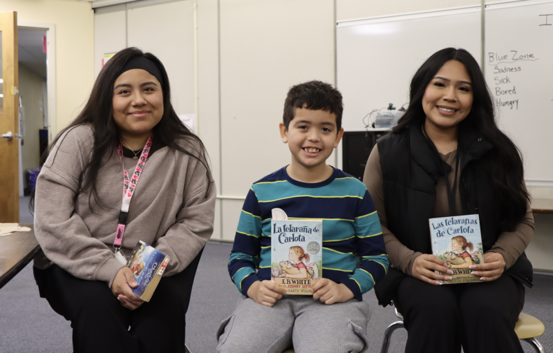 Student and staff members of the Northside Elementary School Spanish Book Club smiling while holding Spanish copies of the book "Charlotte's Web"