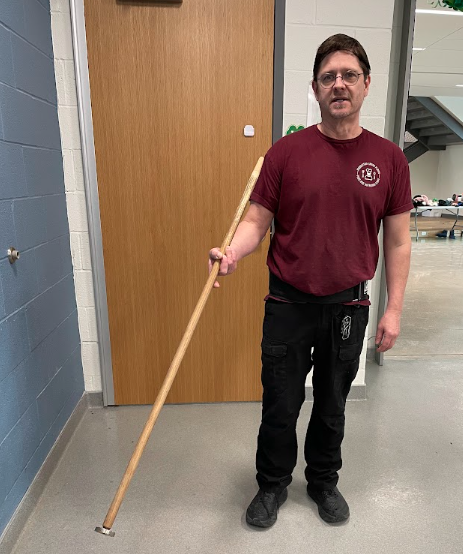 Cook Cliff Curtis with his magnetized tool to remove silverware from garbage