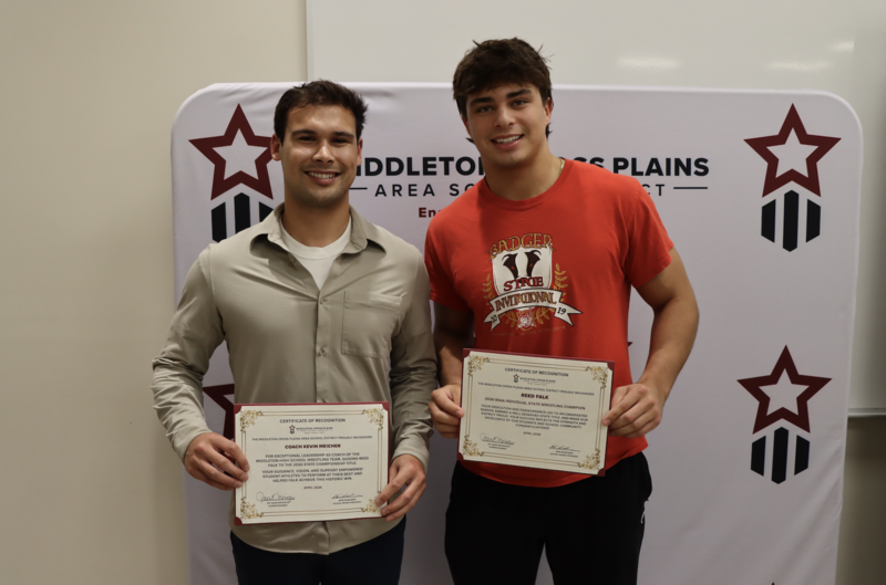 Wrestling Coach Kevin Meicher and junior Reed Falk smiling and holding certificates