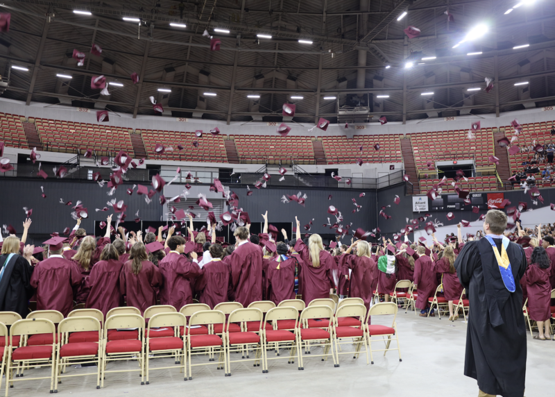 Class of 2025 graduates tossing their caps in the air after the 2025 graduation ceremony