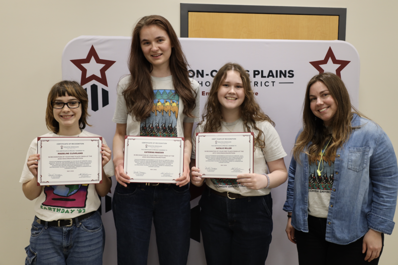 Madeline Cleveland, Katya Maeder, Natalie Miller, and Leah Williams smile and pose with certificates