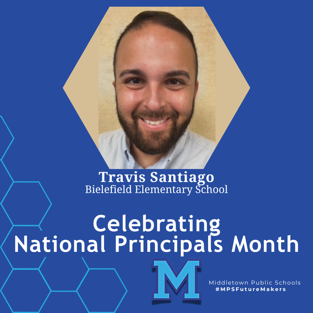A man with a beard smiling in front of a light brown background. The image celebrates National Principals Month and includes school branding.