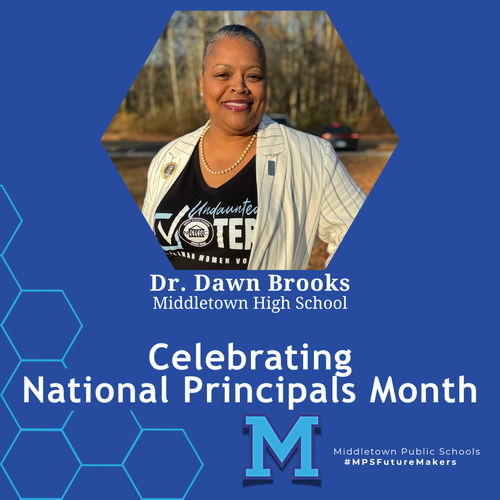 A woman standing and smiling in front of an outdoors background. The image celebrates National Principals Month and includes school branding.