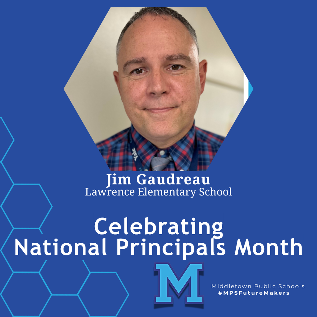A man wearing a checkered shirt and tie in front of a plain backdrop. The image celebrates National Principals Month and includes school branding.