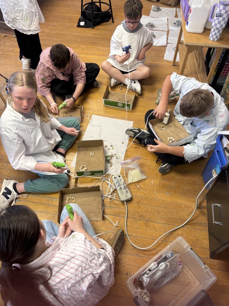 kids gluing their bowls on their box