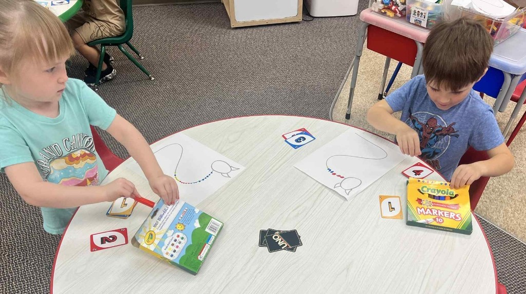 2 kids making Uno monsters