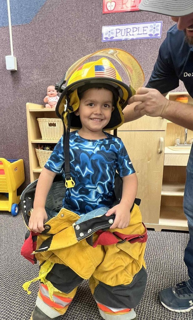 a boy trying on the fire fighting uniform