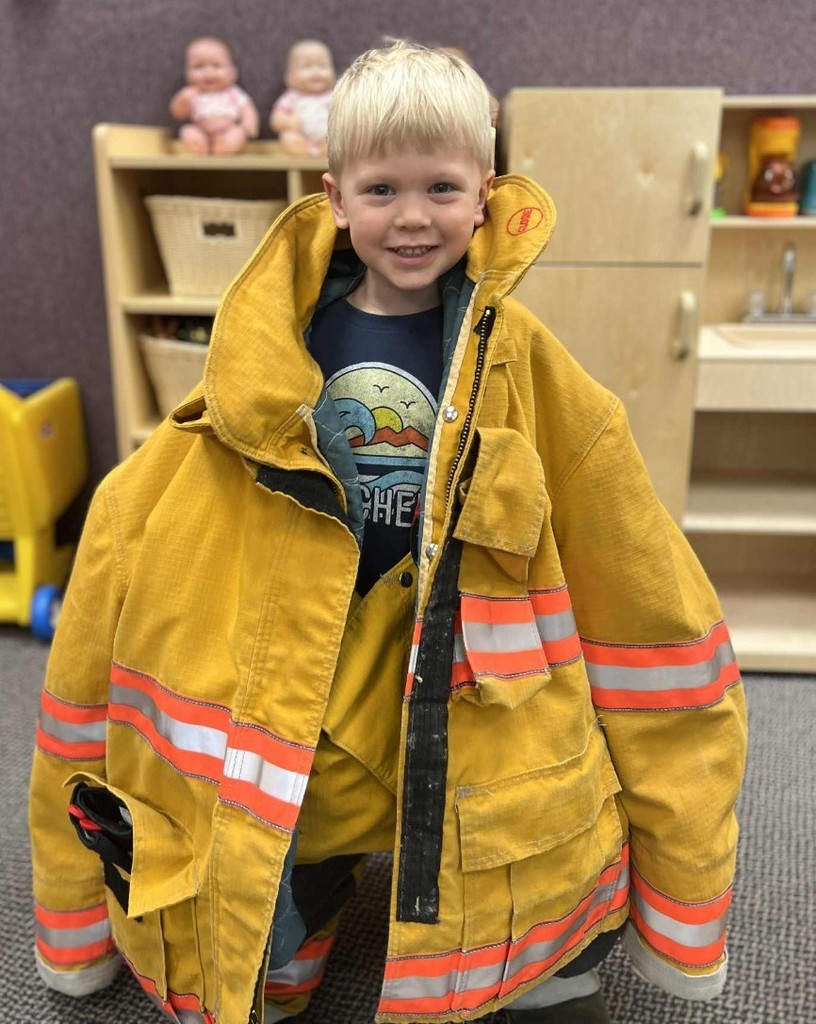 a boy trying on the coat.