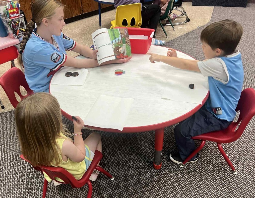 a girl reading to preschoolers 