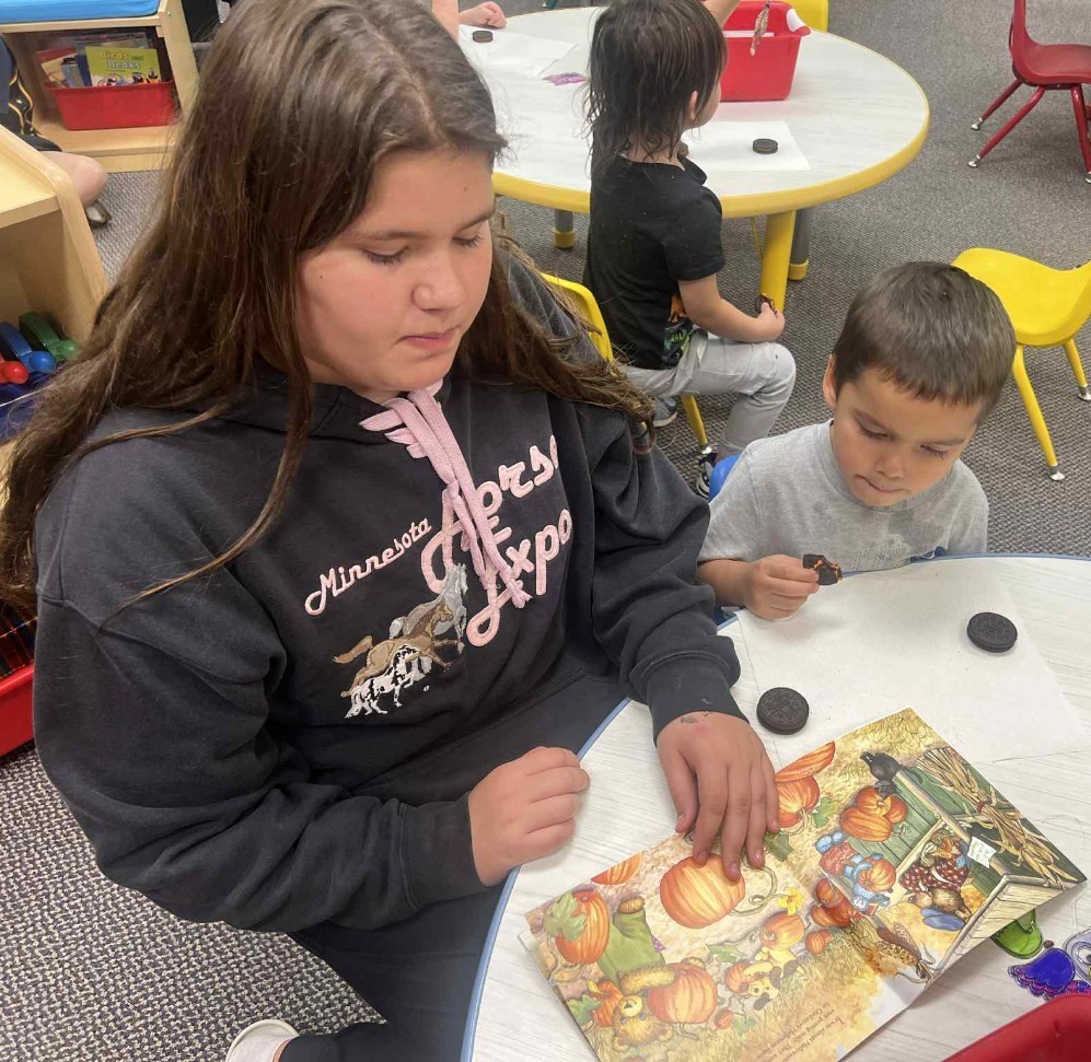 a girl reading to her brother.